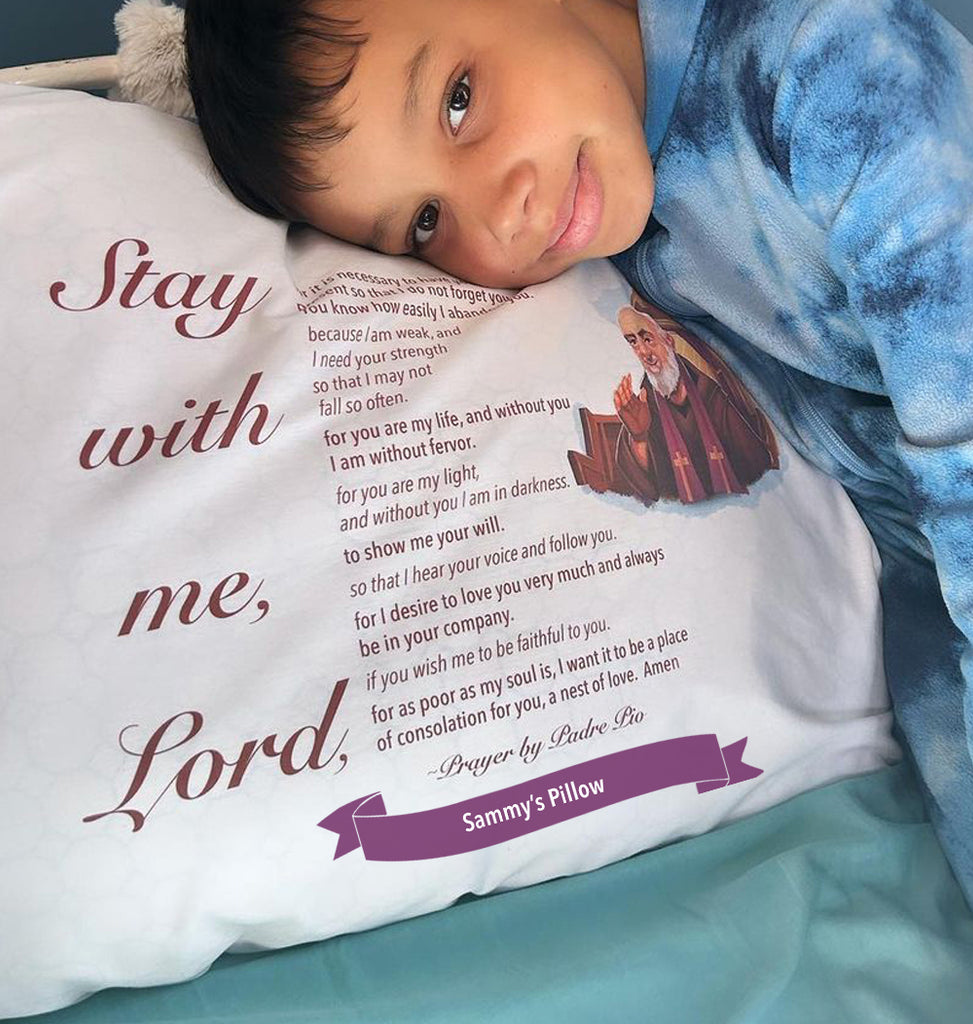 Child leaning on personalized Padre Pio pillowcase