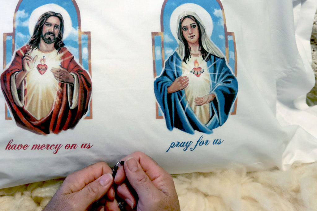 Catholic pillowcase adorned with Sacred Heart of Jesus and Immaculate Heart of Mary shown with praying hands