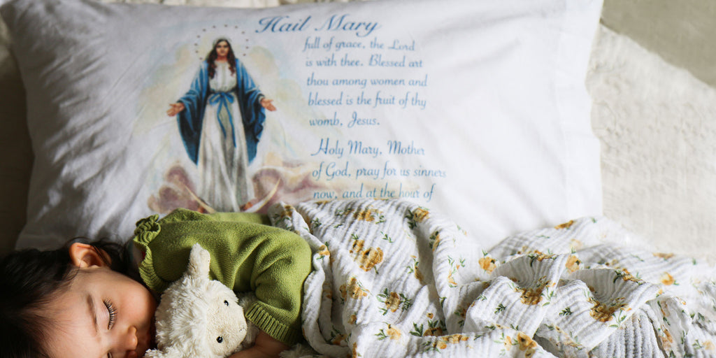 Baby sleeping with a Hail Mary pillow.